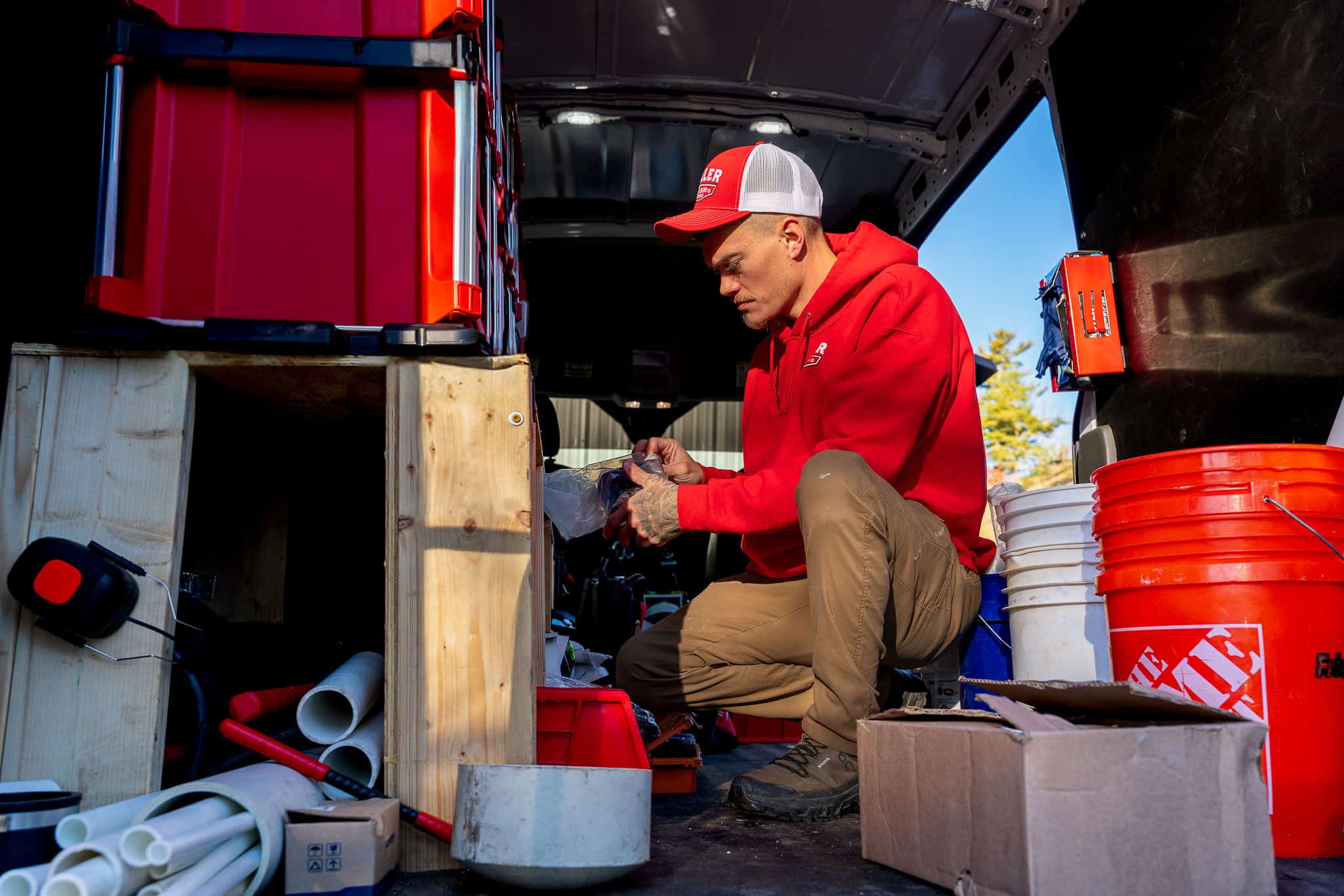 Inside a Miller Plumbing truck — bins of fittings, PVC, and tools, organized and ready.