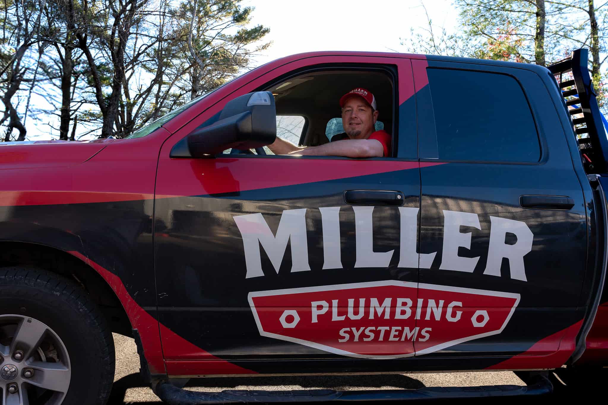 A Miller Plumbing technician behind the wheel of a service truck, headed to a job in the High Country.